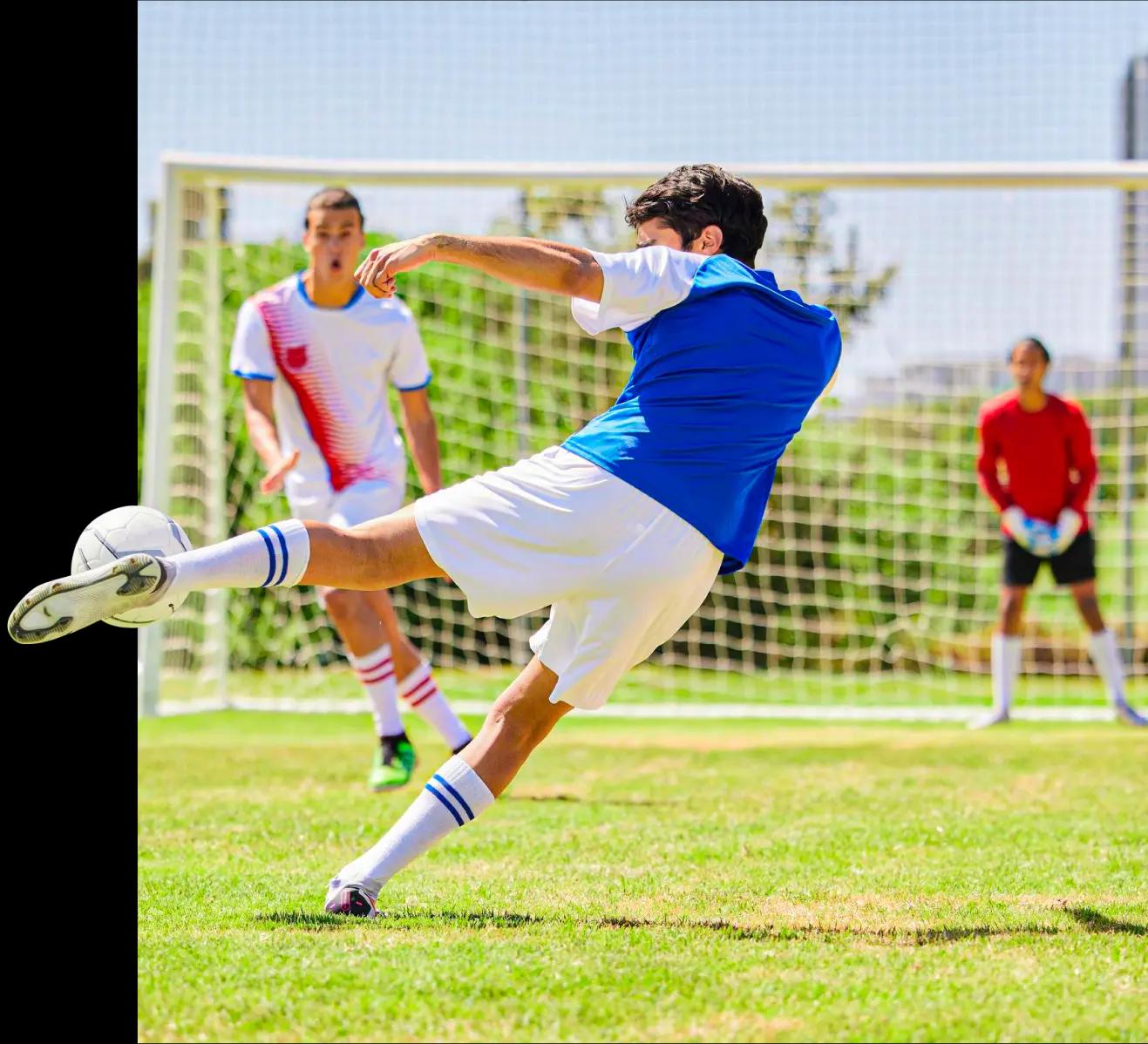 Player shoots the ball in front of a defender and a goalkeeper